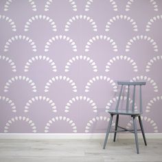 a wooden chair sitting in front of a wallpapered with white circles on it