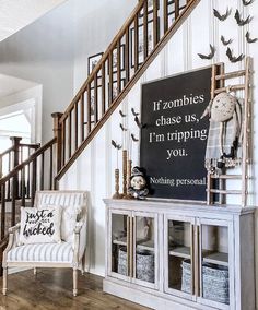 a living room with white furniture and a staircase leading up to the second floor that is decorated in black and white