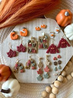 a table topped with lots of different types of earrings and pumpkins on top of it