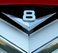 the hood ornament of a classic car with chrome trim and logo on it