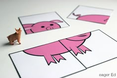 pink pigs cut out on white cards with brown horse figurine next to them