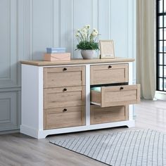 a white and wood dresser with drawers in a room