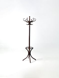 a coat rack with two candles on it and one candle holder in the shape of a tree