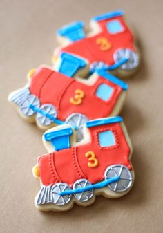 two decorated cookies sitting on top of a table next to each other, one is red and the other is blue