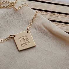 a gold plated necklace with the words grace, love and peace written on it