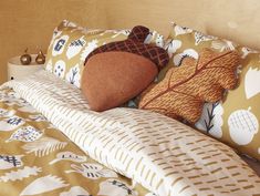 a bed topped with lots of pillows next to a wooden headboard and night stand