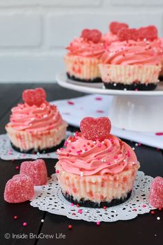 cupcakes with pink frosting and heart shaped candies