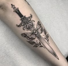 a black and white photo of a knife with flowers on the side of its arm