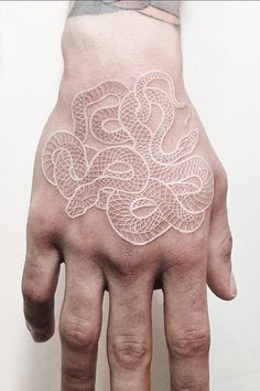 a person's hand with a white tattoo on the left side of their palm