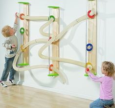 two children playing with wooden toys on the wall