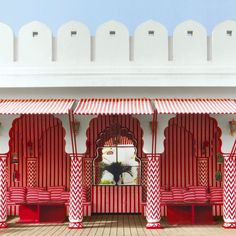 a red and white striped building with benches