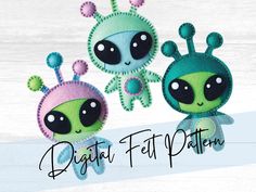 two little alien dolls sitting next to each other on top of a wooden surface with the words digital felt pattern