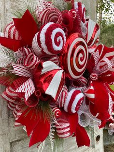 a wreath with red and white candy canes hanging from the side of a door