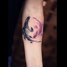 a woman's arm with a watercolor painting style tattoo on the left forearm