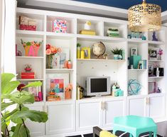 a living room filled with lots of white bookshelves covered in colorful accessories and decor