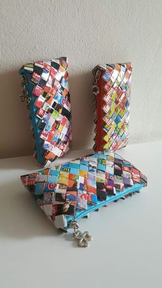 two colorful purses sitting next to each other on a white counter top in front of a wall