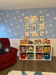 a child's playroom with toys and pictures on the wall, including a red chair