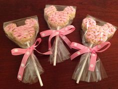 three heart shaped lollipops wrapped in cellophane and tied with pink ribbon