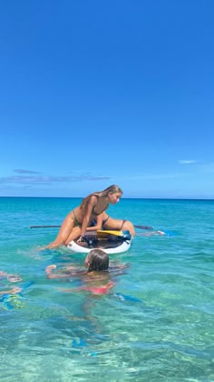 two people are in the water on their surfboards and one person is paddling