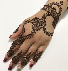 a woman's hand with henna tattoos on it