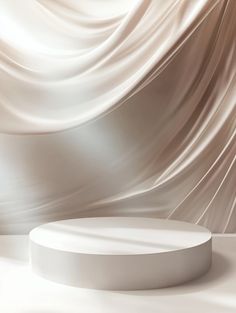 a round white table sitting on top of a floor next to a wall covered in silk