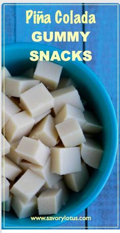 a blue bowl filled with cubed cheese on top of a wooden table