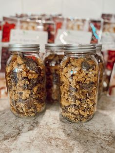 two jars filled with granola sitting on top of a counter