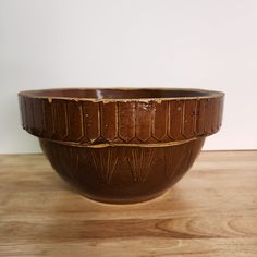 a brown bowl sitting on top of a wooden table