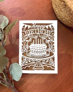 a birthday card sitting on top of a wooden table next to a potted plant