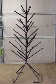 a metal christmas tree sitting in front of a garage door