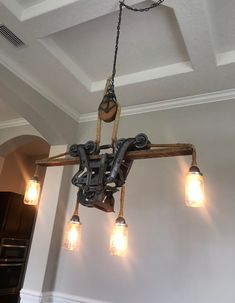 a chandelier hanging from the ceiling in a room with lights on and exposed pipes