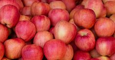 a pile of red apples sitting next to each other