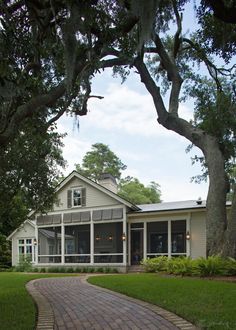 This home, nestled between large oaks and draped in Spanish moss, offers complete privacy overlooking the Wilmington River. A white picket gate and crushed stone drive lead to the welcoming front entrance, with glowing gas lanterns lighting the way. Inside, the open living area includes a dining room, great room, and eat-in kitchen. Sliding and French doors connect to a screened back porch, offering serene river views. The Master Suite, with a private outdoor shower, is off the main hall, while guest suites can be separated or integrated with the living space, creating a perfect blend of comfort and functionality. Four Seasons Private Residences, Crushed Stone, Picket Fence