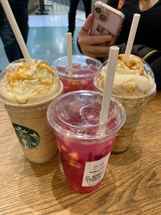 three starbucks drinks are sitting on a table