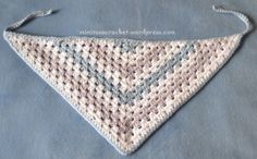 a crocheted triangle is sitting on a blue blanket