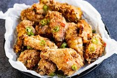 a bowl filled with fried food sitting on top of a black table next to a white napkin