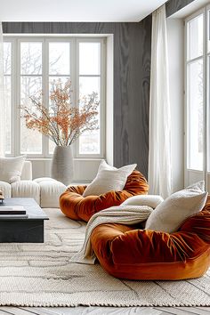 a living room filled with lots of furniture and large windows in the wall behind it