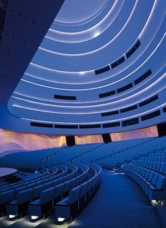 an empty auditorium with rows of seats and lights on the ceiling is lit up at night