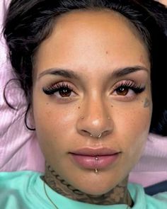 a close up of a person with tattoos on her face