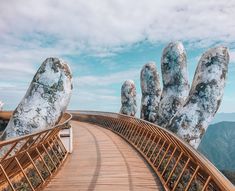 a wooden bridge with hand prints on the sides and mountains in the backgroud