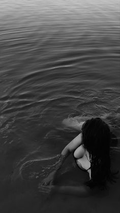 a woman in the water with her back to the camera