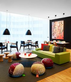 a living room filled with lots of furniture next to a large painting on the wall