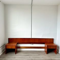 a wooden bench sitting in the corner of a room