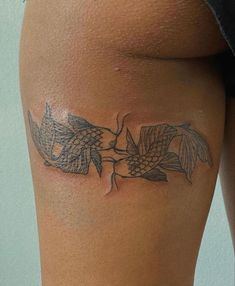 a woman's thigh with fish tattoos on it