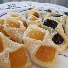 small pastries are on a plate with blueberries and oranges in the middle