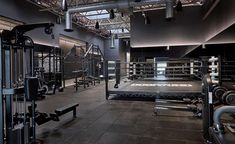 a gym with rows of exercise equipment in the middle and overhead lighting on the ceiling