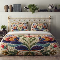 a bed with an intricately designed comforter and pillows