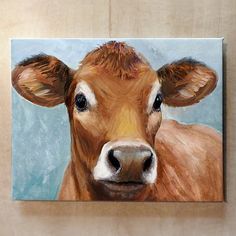 a painting of a brown cow is hanging on the wall