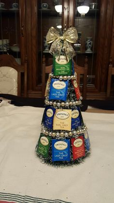 a christmas tree made out of beer cans on top of a white tablecloth covered table