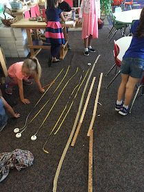 children are playing with wooden train tracks on the floor